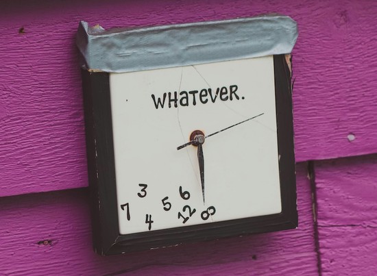 A clock made to look like all of the numbers have fallen down to the bottom of the face, with the word whatever showing above