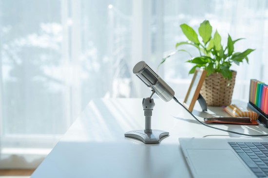 A microphone sitting on a desk next to a laptop